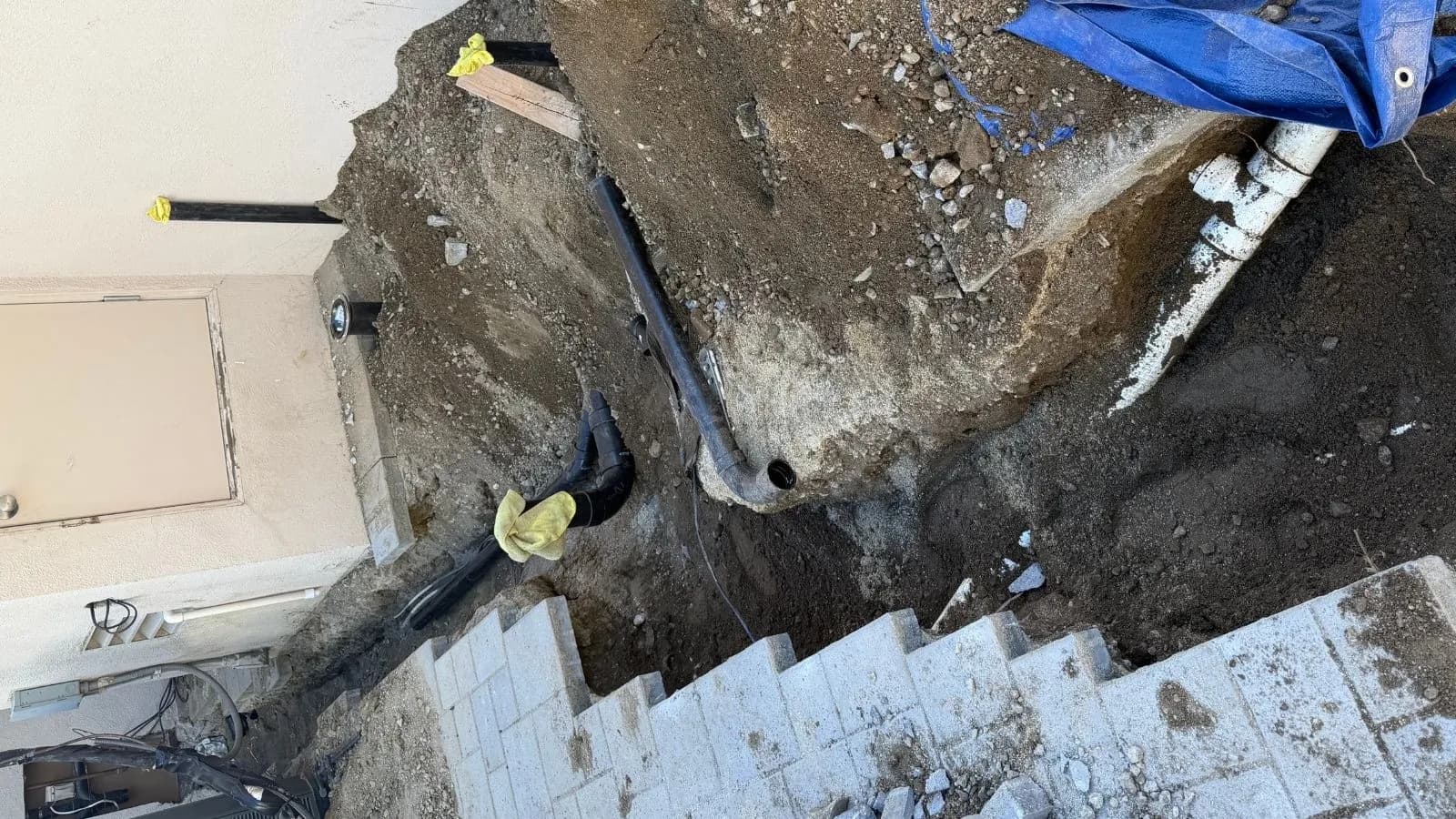 Carefully removed pavers exposing sewer line trench for outdoor BBQ installation in Burbank